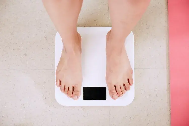 Woman on scales looking for easy natural weight loss
