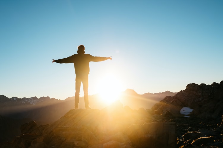 man on hill with sunrise